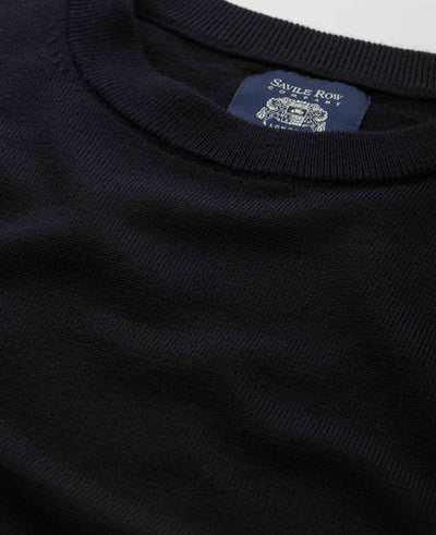 Close-up of a dark navy ribbed knit crewneck sweater showing the inner neck label which reads 'Savile Row London'.