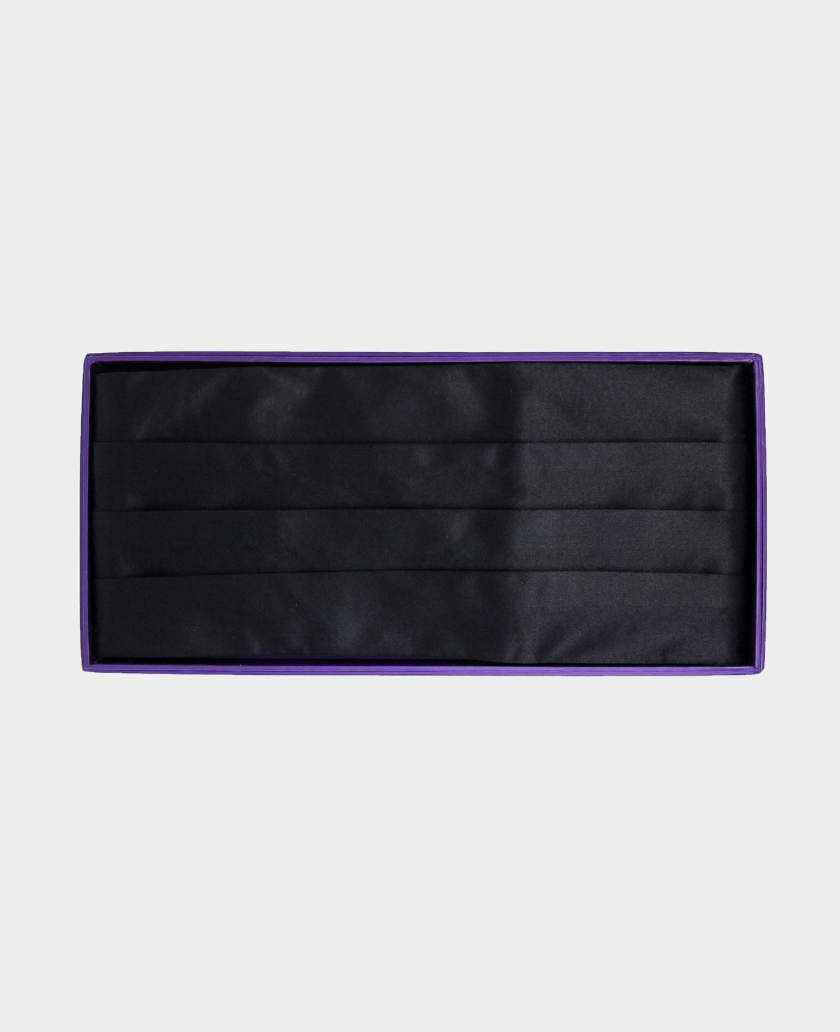 A black necktie set inside a purple presentation box, photographed flat against a light gray background.