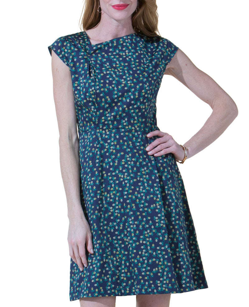 Woman wearing a blue pineapple dress on a white background